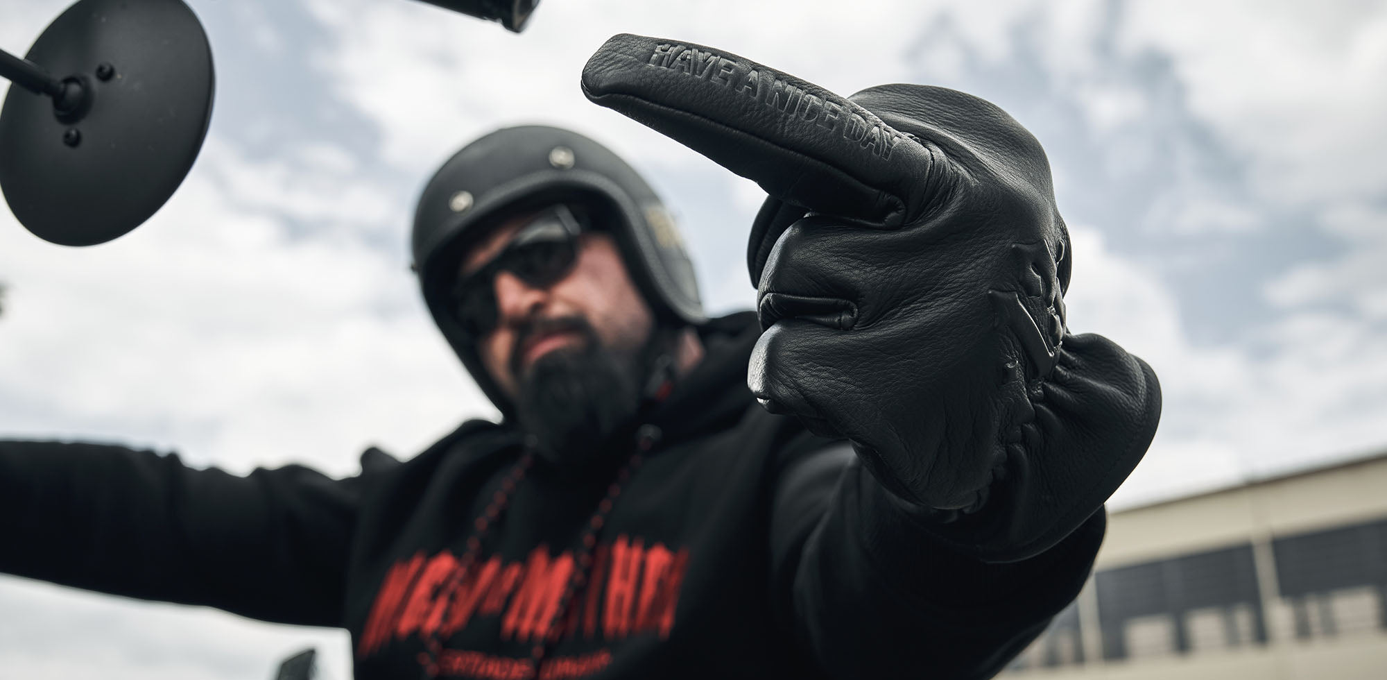 mann sitztend auf motorrad trägt men of mayhem lederhandschuhe mofo und classic hoody in schwarz rot