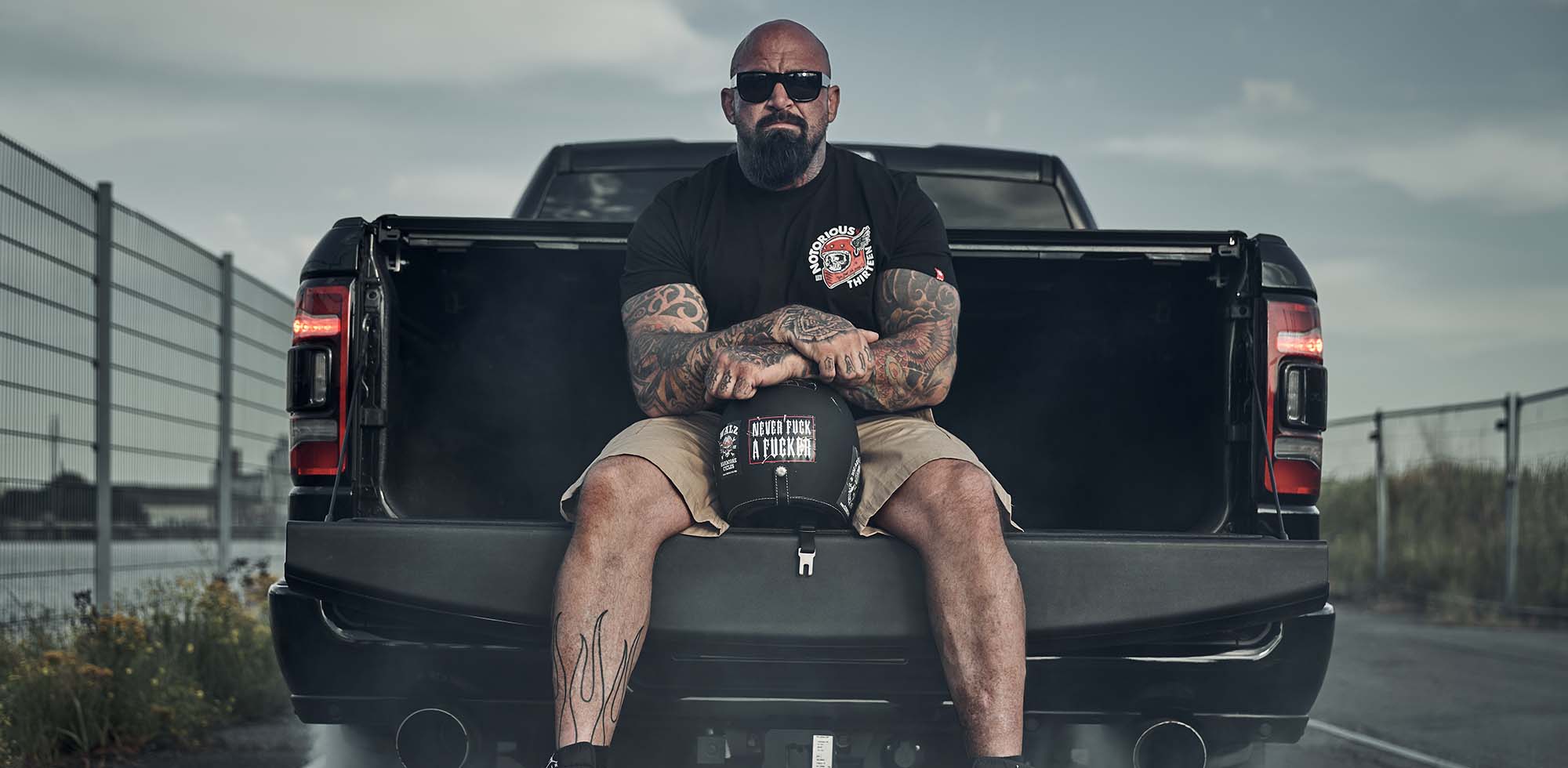 mann sitzend auf dodge ram in schwarz trägt men of mayheem t-shirt deathwing in schwarz rot