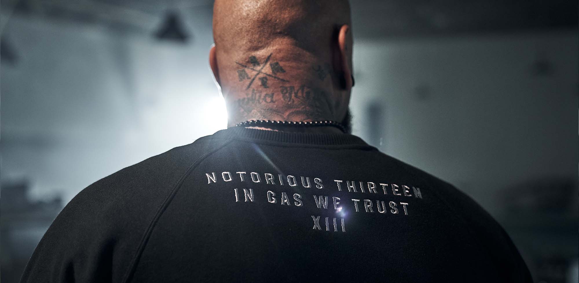 mann trägt men of mayhem crewneck one in schwarz zu sehen ein stick im nacken mit der aufschrift notorious thirteen