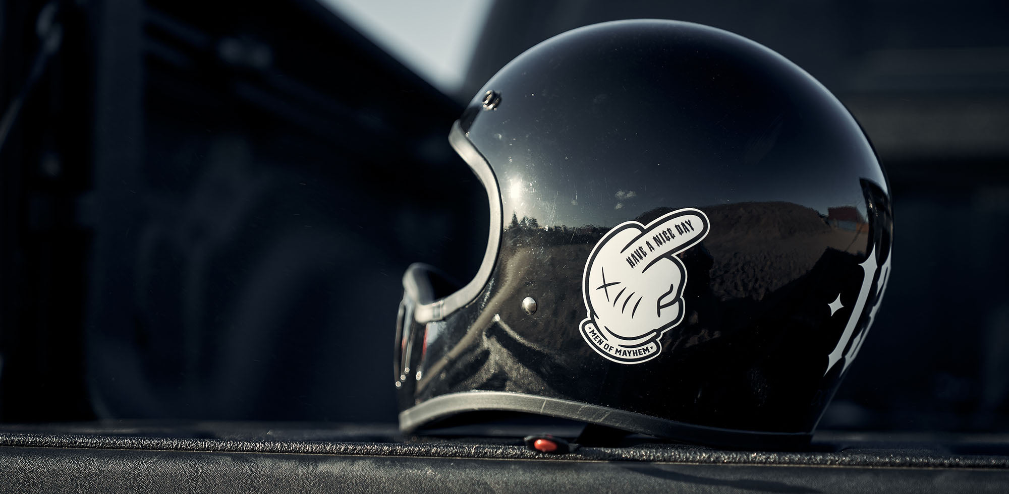 schwarzer helm mit weißem men of mayhem middle finger sticker und weißer 13 auf dem motorradhelm
