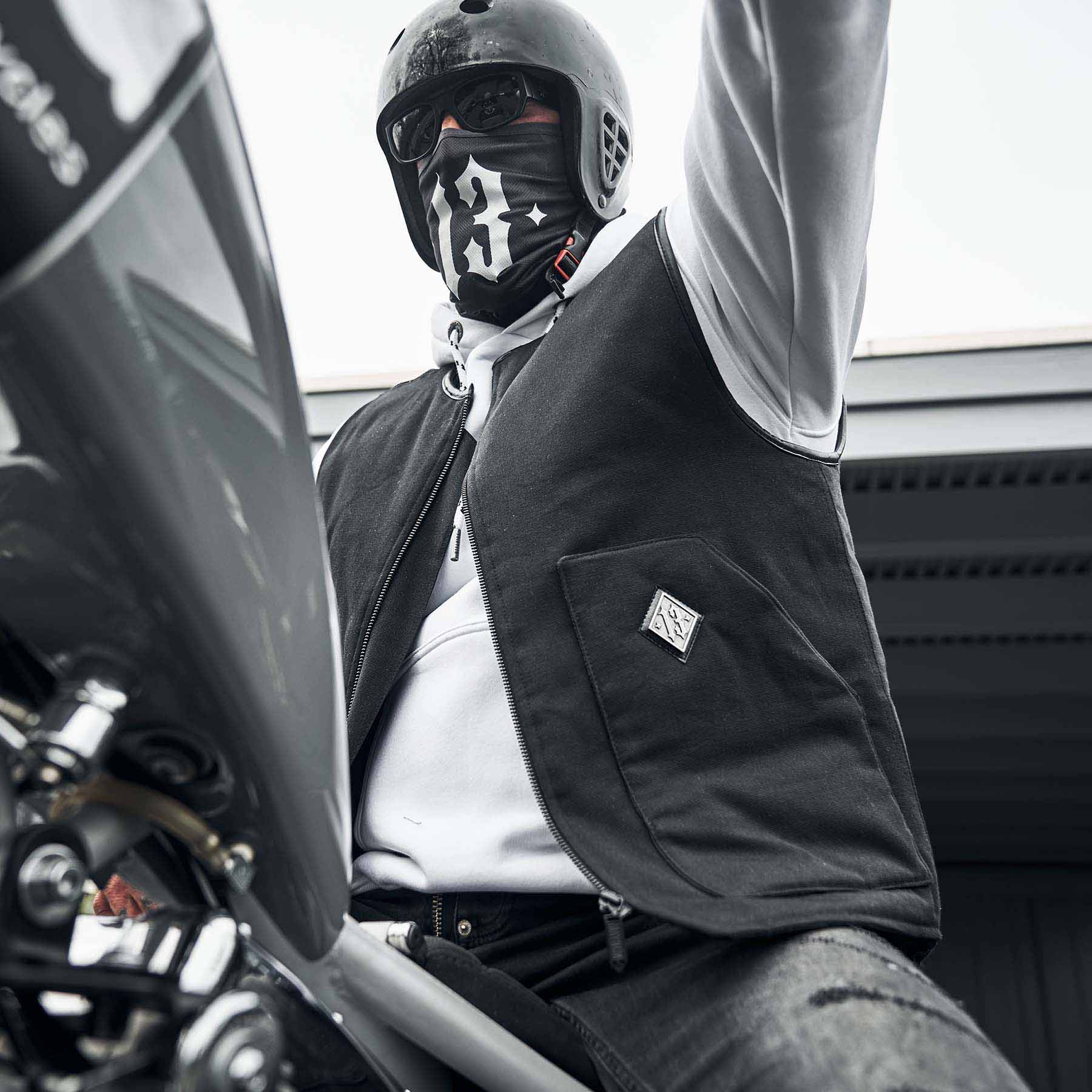 mann sitzend auf harley davidson trägt men of mayhem weste und bandana mit 13