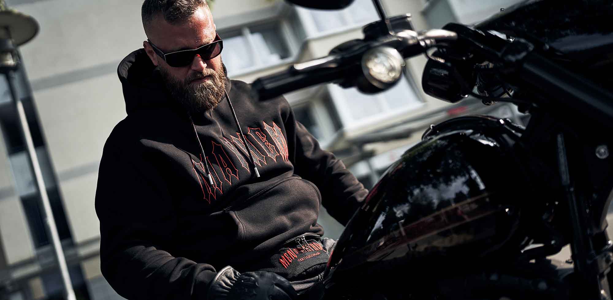 mann mit schwarzem men of mayhem hoody mit logo stick auf front und rücken