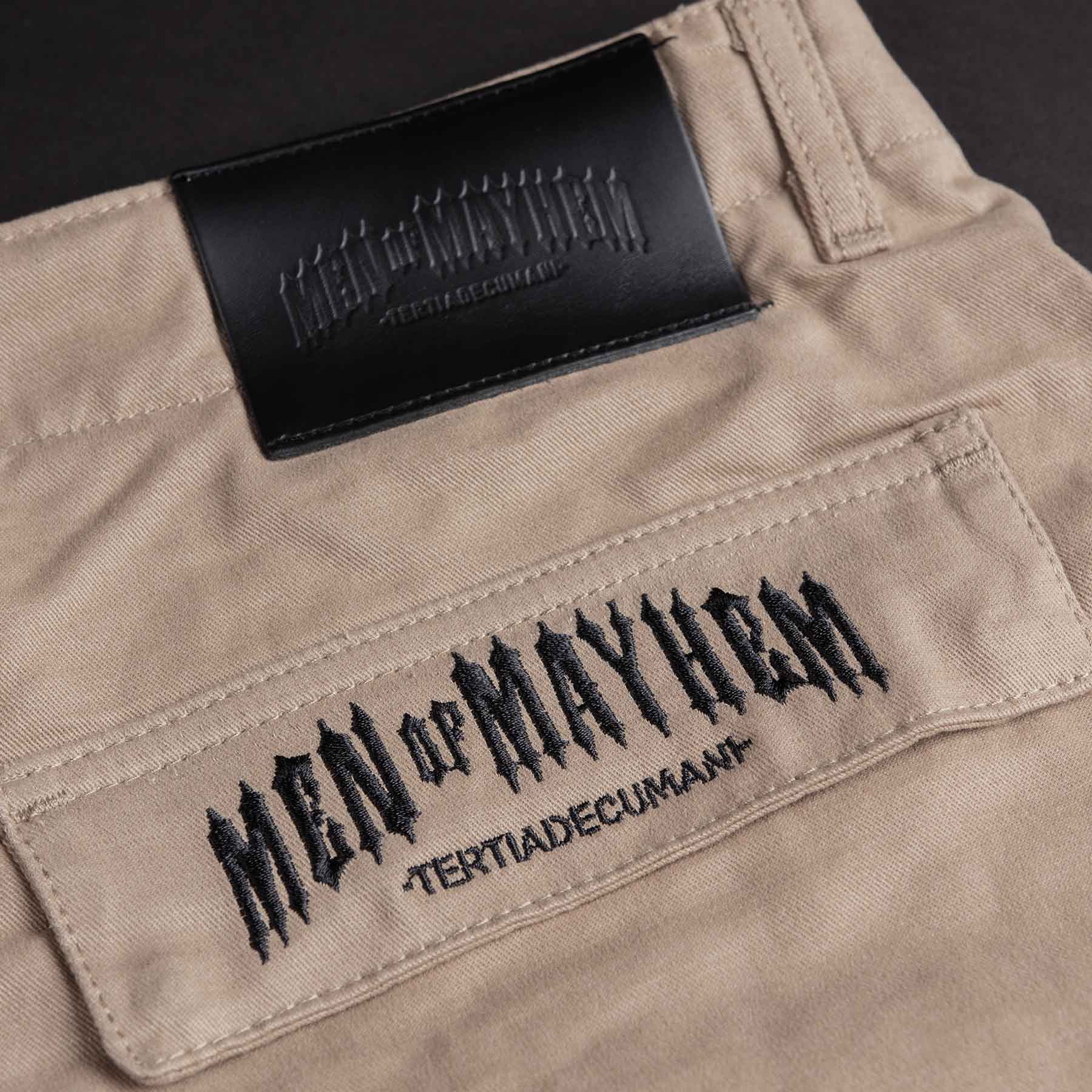 nahaufnahme einer men of mayhem cargo hose in sand mit schrazem mayhem stick auf der gesäßtasche