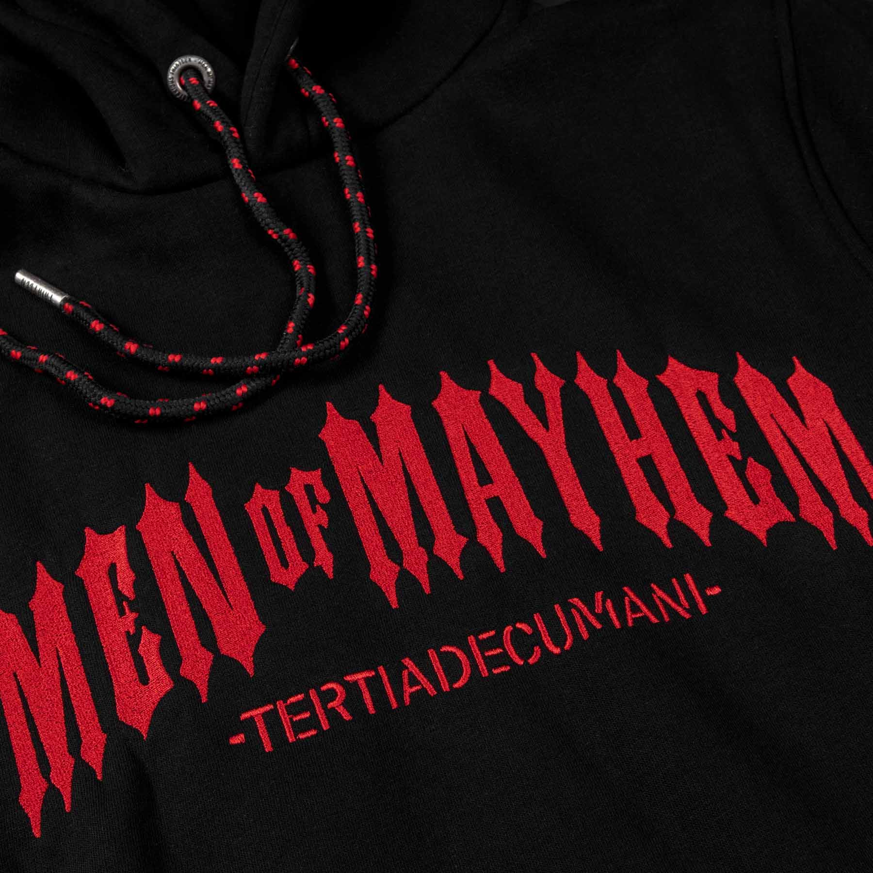 Nahaufnahme eines men of mayhem classic hoodies in schwarz mit rotem logo stick über die brust