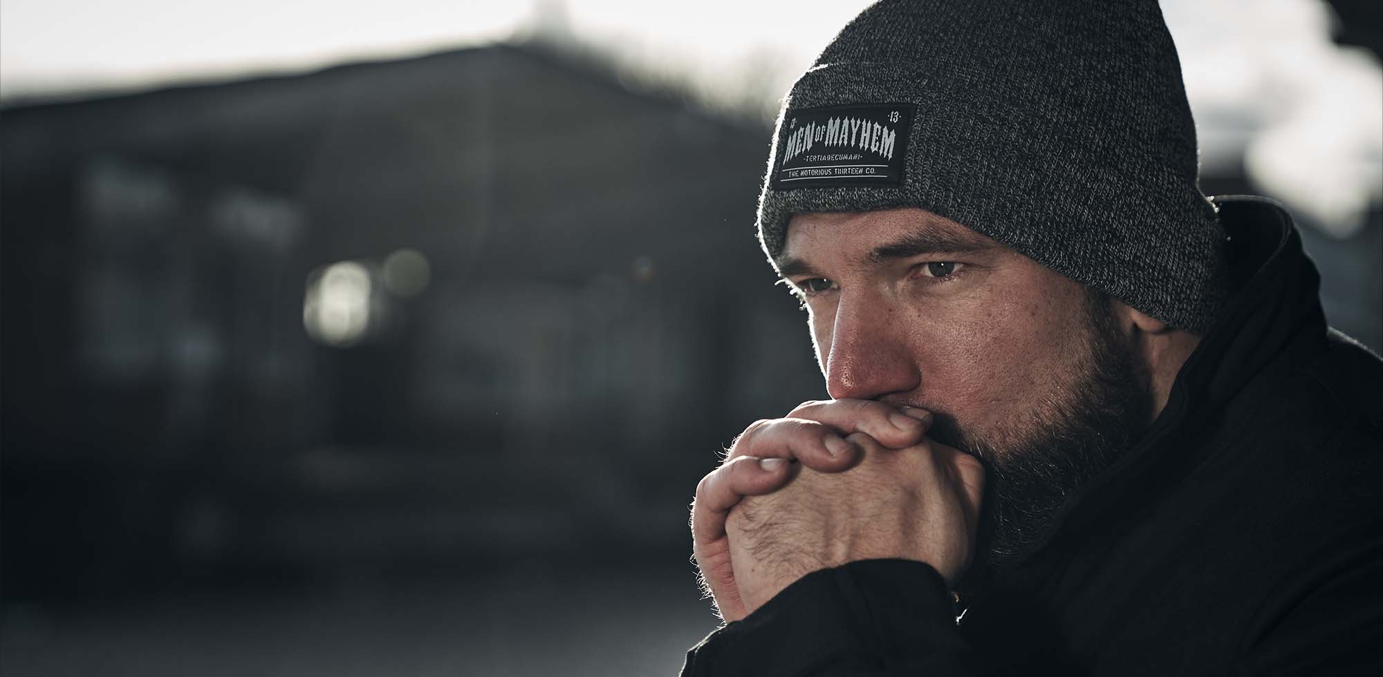 mann trägt mütze bzw beanie von men of mayhem in grau mit schwarzem logo label an der front und weißer schrift