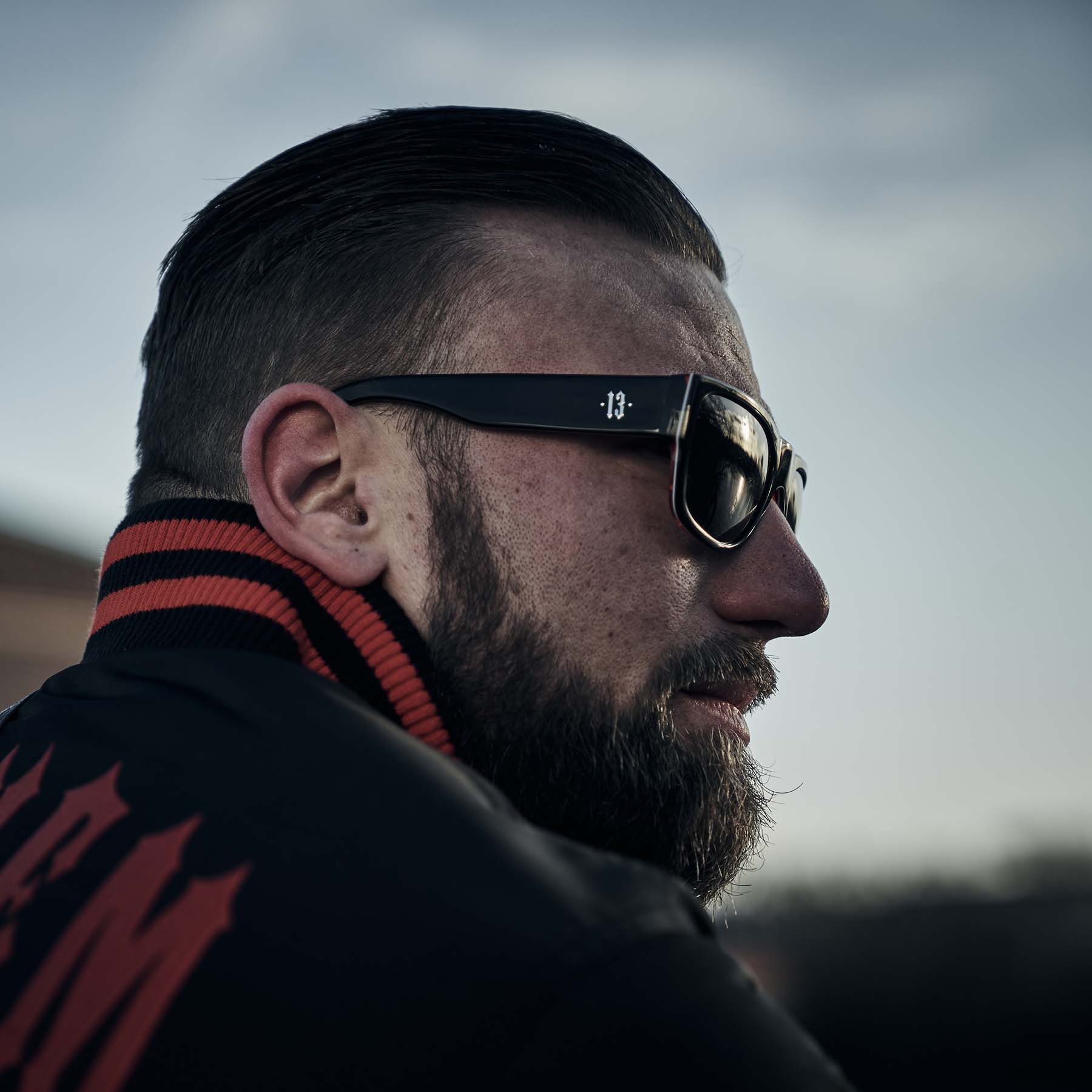 mann trägt men of mayhem sonnenbrille in schwarz mit silber farbender 13 am gestell