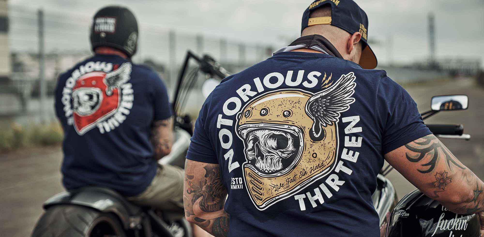 2 männer auf motorrädern tragen men of mayhem deathwing t-shirts in navy gold und navy rot